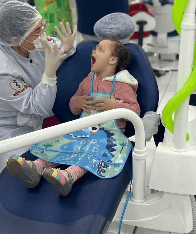 Atendimento preventivo infantil no consultório da Dra. Ana Beatriz — criança sorridente durante consulta odontológica